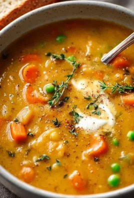 Creamy vegetable soup in a pot with fresh ingredients and herbs