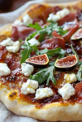 Fig Jam Pizza topped with goat cheese and prosciutto slice on a wooden board