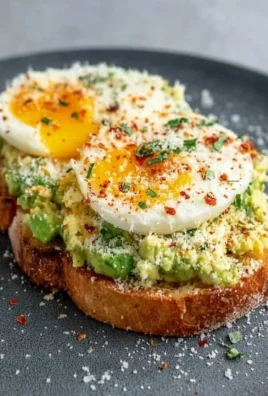 Delicious grated egg avocado toast topped with fresh herbs on whole grain bread.
