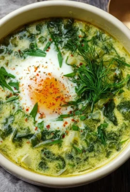 Bowl of Green Borscht, a traditional Ukrainian sorrel and spinach soup with fresh herbs.