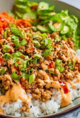 Ground Turkey Rice Bowl garnished with Bang Bang Sauce and fresh vegetables
