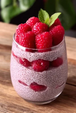 Delicious Raspberry Chia Pudding served in a glass bowl with fresh raspberries.
