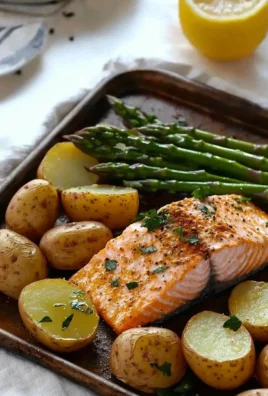 Salmon, potato, and asparagus on a sheet pan for a healthy meal.