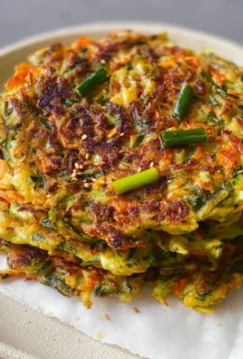 Delicious vegan vegetable pancakes served on a plate with fresh vegetables.