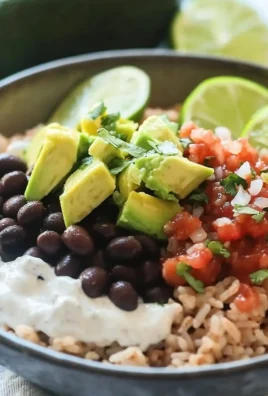 Colorful bean and rice burrito bowls topped with fresh ingredients.
