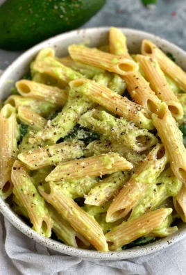 Creamy avocado pasta dish topped with fresh herbs and ready to serve