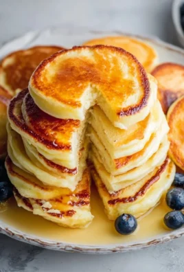 Fluffy lemon ricotta pancakes served with fresh berries and syrup