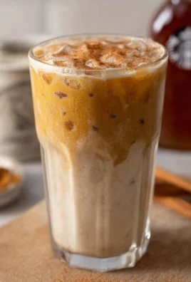 Starbucks Iced Pumpkin Cream Chai Latte topped with pumpkin spice and cream