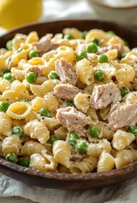 Bowl of Tuna Pasta Salad with fresh vegetables and dressing