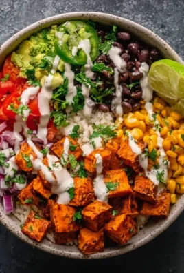 Vegan sweet potato burrito bowl with fresh vegetables and toppings