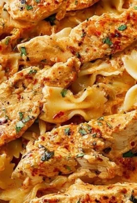 Delicious Bang Bang Chicken Pasta served in a bowl with herbs and spices.