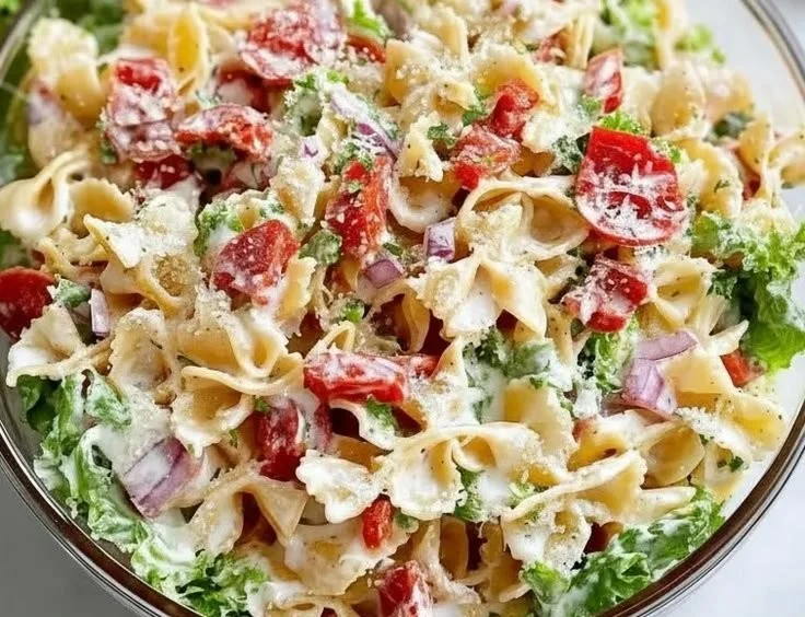 A bowl of BLT Pasta Salad with bacon, lettuce, and tomatoes, perfect for summer meals.