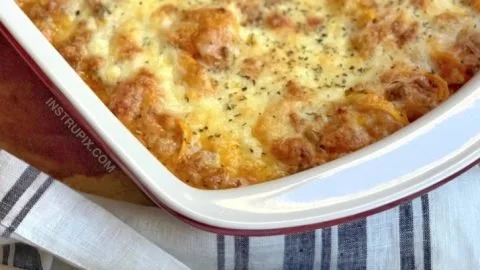 Cheesy baked tortellini casserole topped with meat sauce and cheese