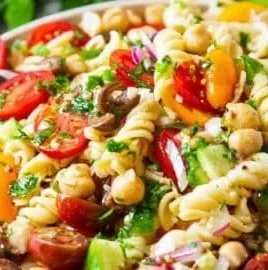 Colorful chickpea pasta salad with fresh vegetables and dressing