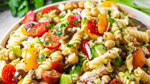 Colorful chickpea pasta salad with fresh vegetables and dressing