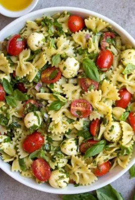 Colorful bow tie pasta salad with fresh vegetables and dressing