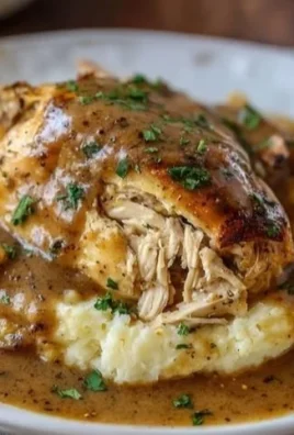 Crockpot chicken and gravy served in a bowl with rice and vegetables