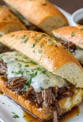 Crockpot French Dip Sandwiches with beef and au jus in a bun