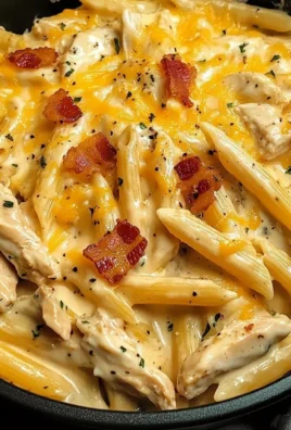 Bowl of creamy Crack Chicken Penne garnished with herbs and cheese