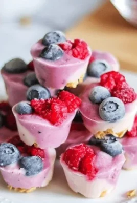 Frozen yogurt berry bites topped with fresh berries and a drizzle of honey.