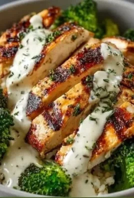 Healthy grilled chicken broccoli bowls topped with creamy garlic sauce.