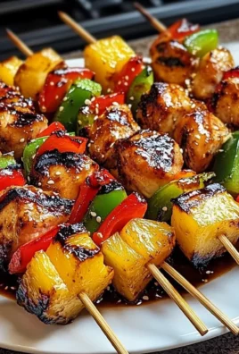 Grilled pineapple chicken kabobs skewered with vibrant vegetables on a BBQ grill