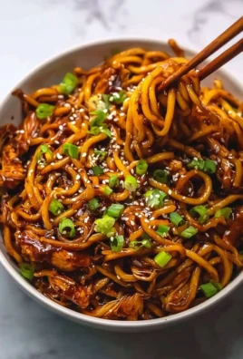 Delicious sticky garlic chicken noodles served in a bowl.