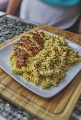 Creamy garlic parmesan chicken pasta served in a bowl with herbs and cheese garnish