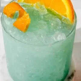 Bright Blue Hawaiian Mocktail served in a glass with pineapple and cherry garnishes.