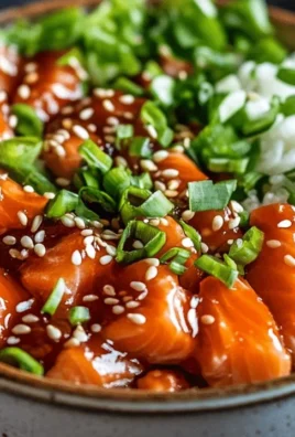 Crispy salmon on a bed of rice in a bowl, garnished with vegetables.