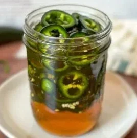 Homemade hot pepper honey with jalapeños for a sweet and spicy flavor.