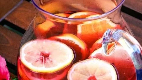 A glass of refreshing Hibiscus Water garnished with hibiscus flowers