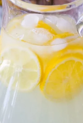 Glass of refreshing homemade lemonade with lemon slices and ice