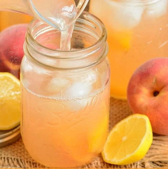 A refreshing glass of homemade peach lemonade with fresh peach slices