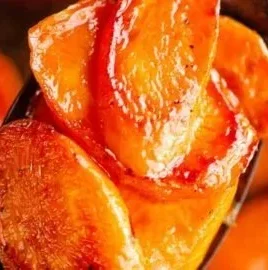 Hot honey glazed carrots on a plate garnished with herbs
