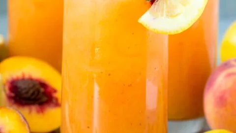 Refreshing peach lemonade in a chilled glass with slices of peach and lemon