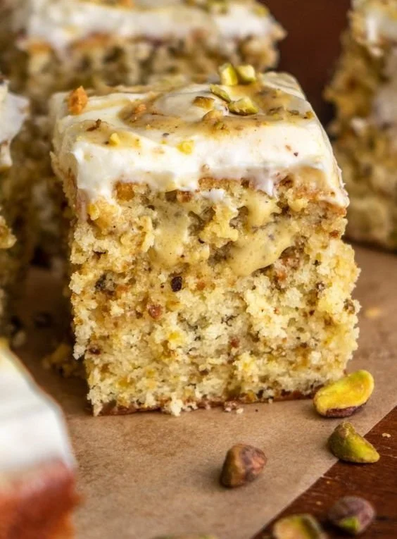 Slice of homemade pistachio cake with frosting and decorations
