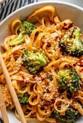 Plate of sweet and spicy tahini noodles with crispy broccoli on top