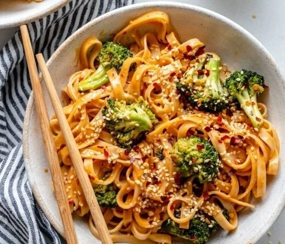 Plate of sweet and spicy tahini noodles with crispy broccoli on top