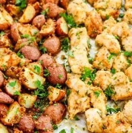 Baked Garlic Parmesan Chicken with crispy potatoes on a white plate