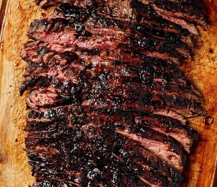 Balsamic flank steak served with grilled zucchini and whipped feta on a plate.