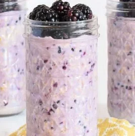Bowl of blackberry overnight oats topped with fresh blackberries and nuts