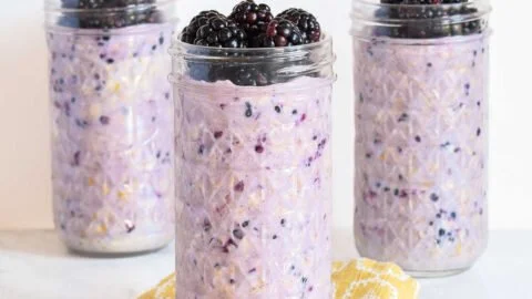 Bowl of blackberry overnight oats topped with fresh blackberries and nuts