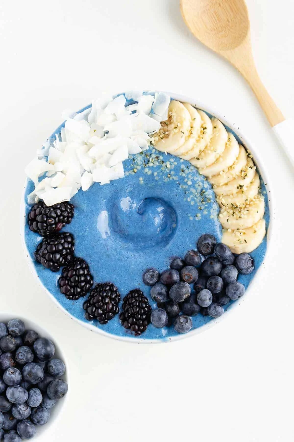 Delicious blue smoothie bowl topped with fresh fruits and nuts