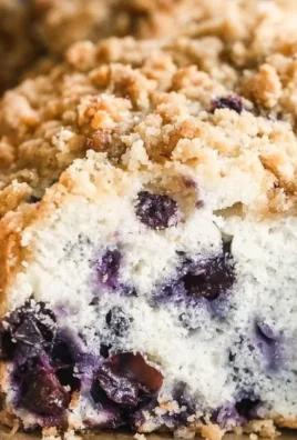 Delicious blueberry coffee cake topped with fresh blueberries and a crumb topping.