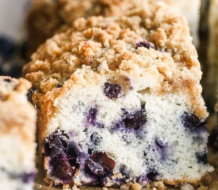 Delicious blueberry coffee cake topped with fresh blueberries and a crumb topping.