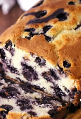 Freshly baked blueberry muffin bread on a wooden cutting board