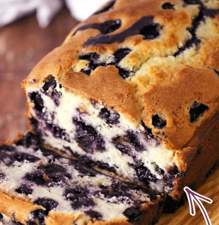 Freshly baked blueberry muffin bread on a wooden cutting board