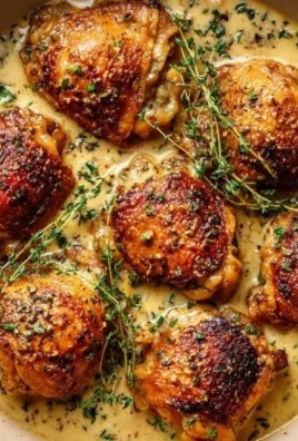 Bobby Flay's chicken thighs served with creamy garlic sauce on a plate