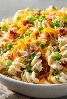 Cheesy bacon ranch pasta salad in a vibrant bowl, garnished with fresh herbs.